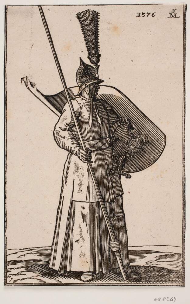 Stående soldat, vendt mod h.; på hovedet en spids hjelm med anselig fjerbusk; i h. hånd en lanse, hvis top er uden for øvre indramningslinje; på v. arm et skjold med indersiden vendt opad — Melchior Lorck